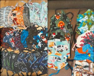 Two photographs of stacks of fabric masks with various fabric patterns and prints