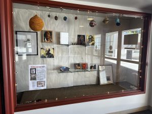 Image of the show installation in the front display case of the library, including several sculptures and two-dimensional works by LWTech employees