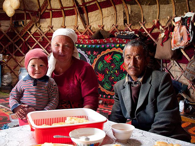 Two Latino grandparents holding their granddaughter