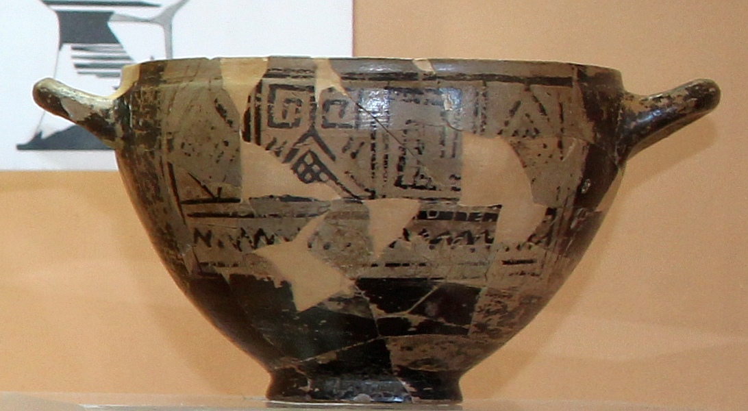 Ancient bowl with two handles, and black markings on brown background