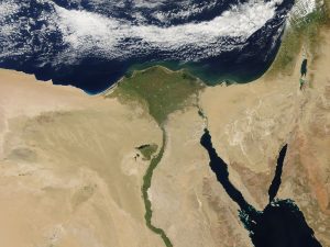 Aerial photo showig mostly desert of Egypt and Near East, with vibrant green just where the Nile flows and empties out into the Mediterranean