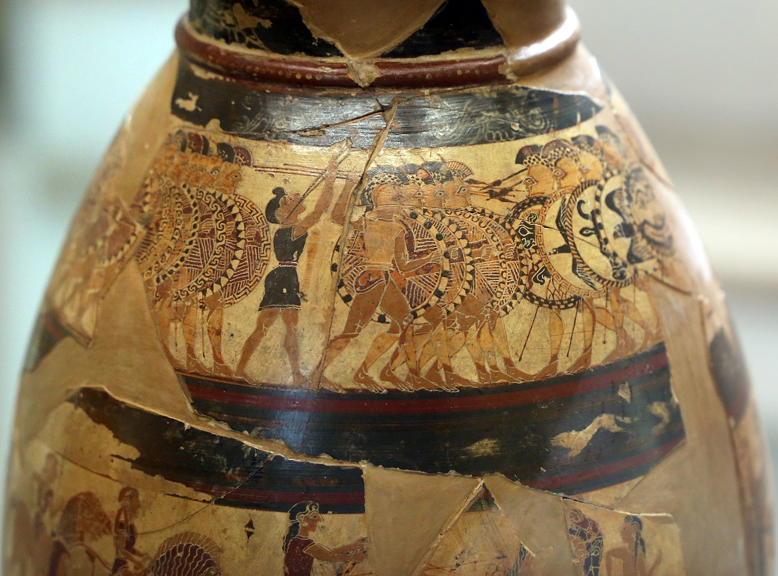 Ancient vase with elaborate paintings of rose of armed men standing tightly together, confronting each other with spears and shields