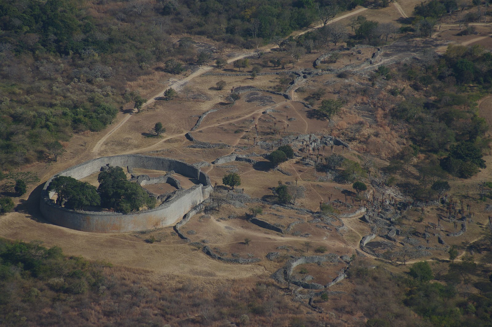 Ruins of a walled city, surrounded by deforested land and more settlement ruins