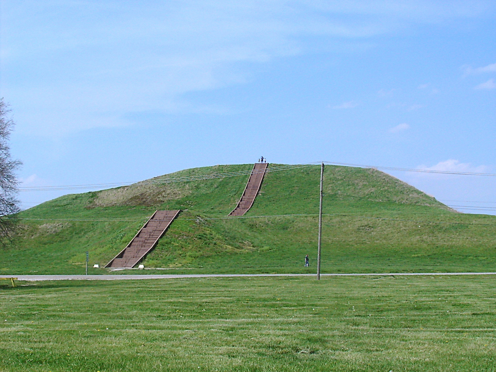 Large mound with steps leading up to top. A few people are walking on mound