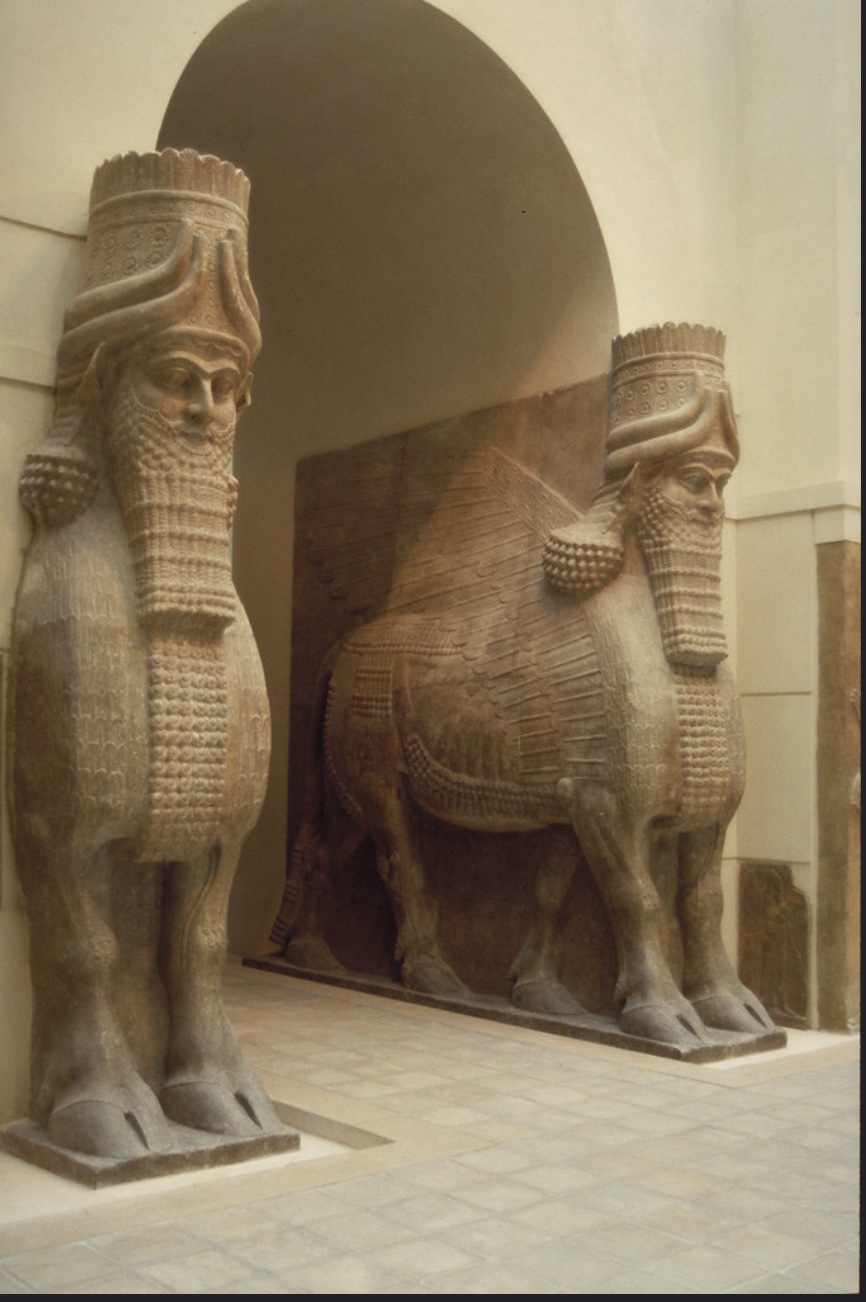 Gateway flanked by two large statues of a bearded man's head atop a winged bull body