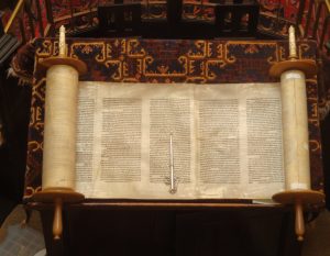 Book scroll open to show dense text in Hebrew