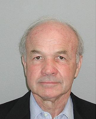 Mug shot of middle-aged man in a black suit and grey shirt