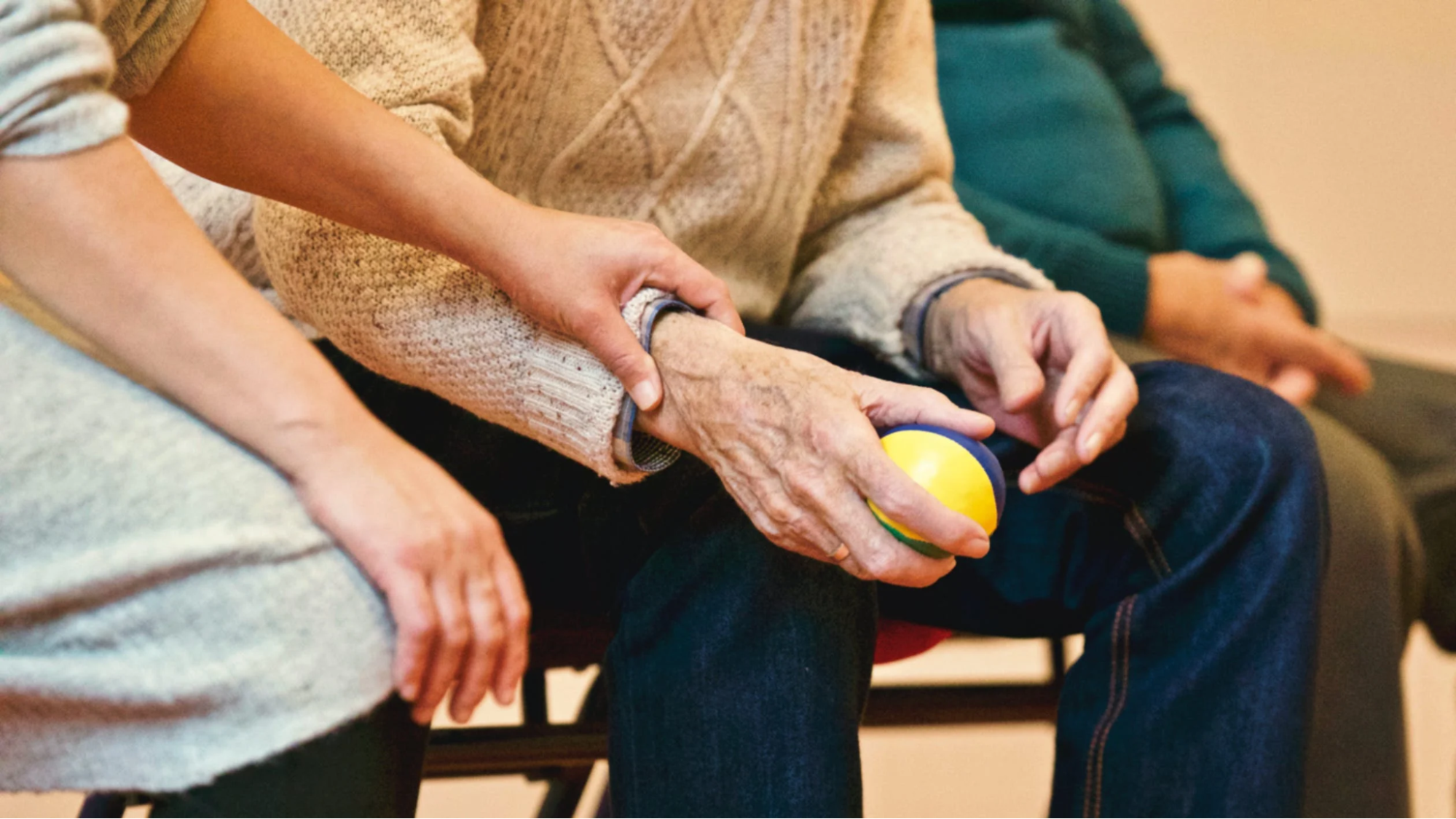 An elderly patient holding a ball in hand