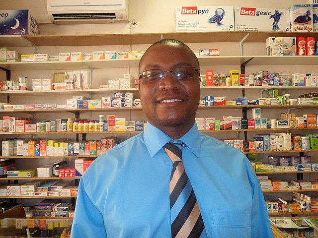 Healthcare professional smiling in a pharmacy