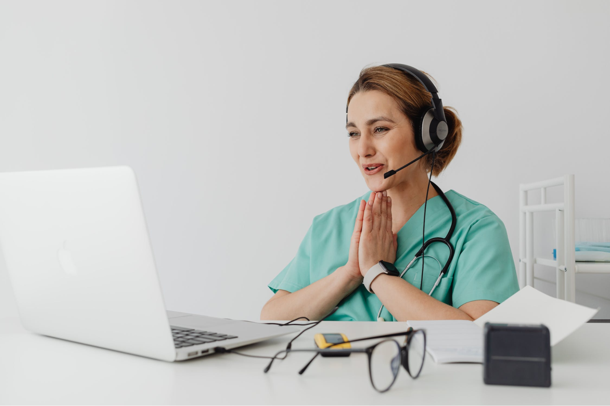 Medical provider facing a computer with a headset on.