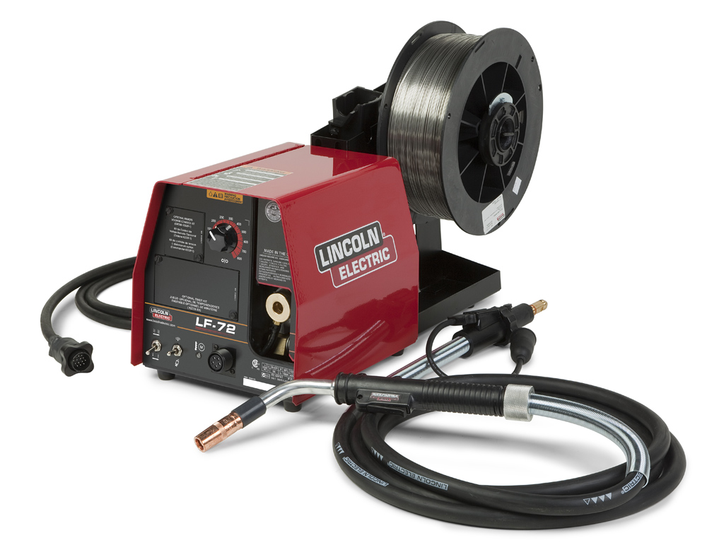 An image of a Lincoln electric wire feeder. It is a red machine with a power cord looped on the left, a spool of wire attached at the back, a welding gun cable and welding gun unattached to the machine on the right.