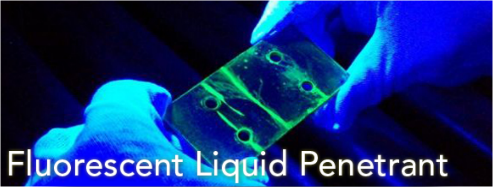 Two gloved hands holding a small rectangular weldment with four holes in it. The background is very dark and the piece is lit up with a blacklight. Fluorescent liquid penetrant is showing up as green on the sample being tested.