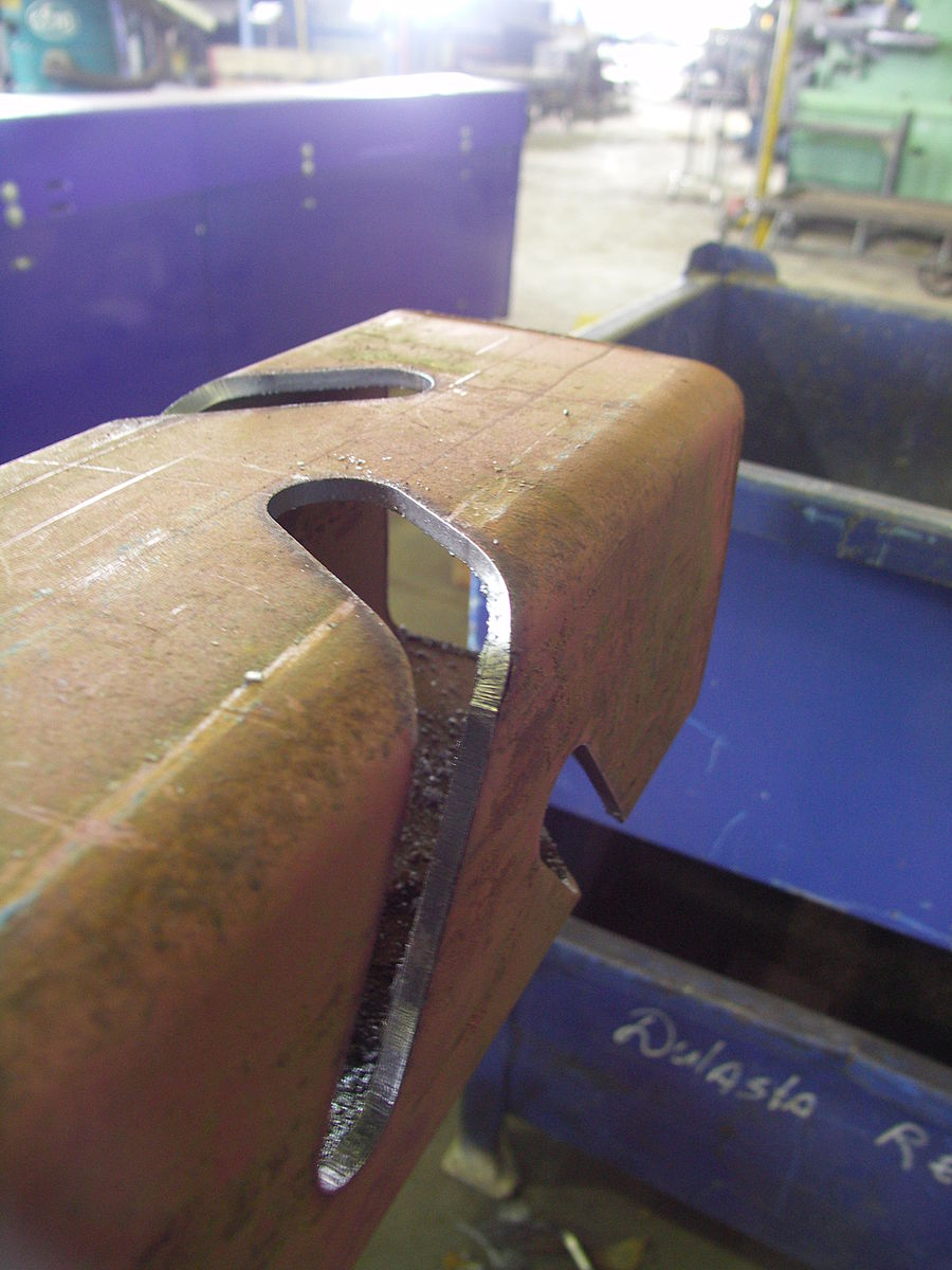 Plasma cut slots at an angle and around a corner. A metal box with rounded edges has two clean-cut slots that were done with plasma arc cutting. The cuts are at an angle and around a corner, and very precise.