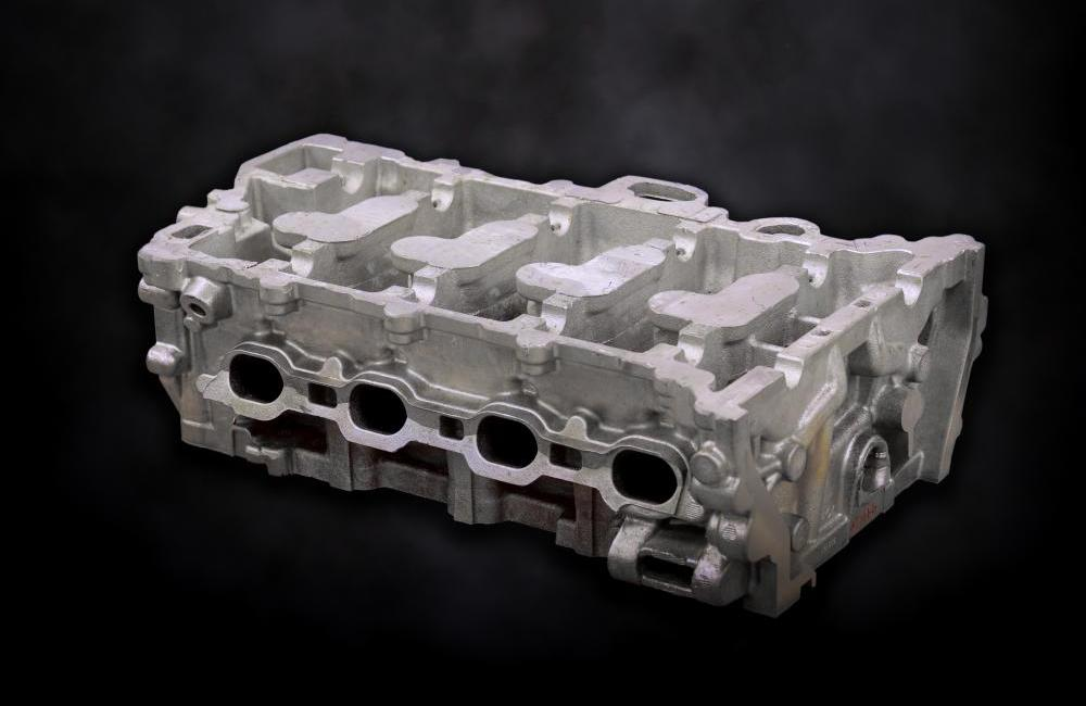 An aluminum engine block on a black background.