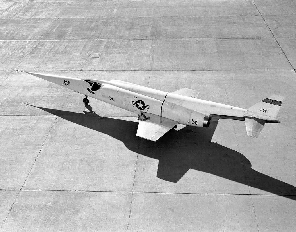 An X-3 Aircraft sits on a flat concrete pad. The aircraft has a very pointed nose, shallow wings, and has no room for passengers.