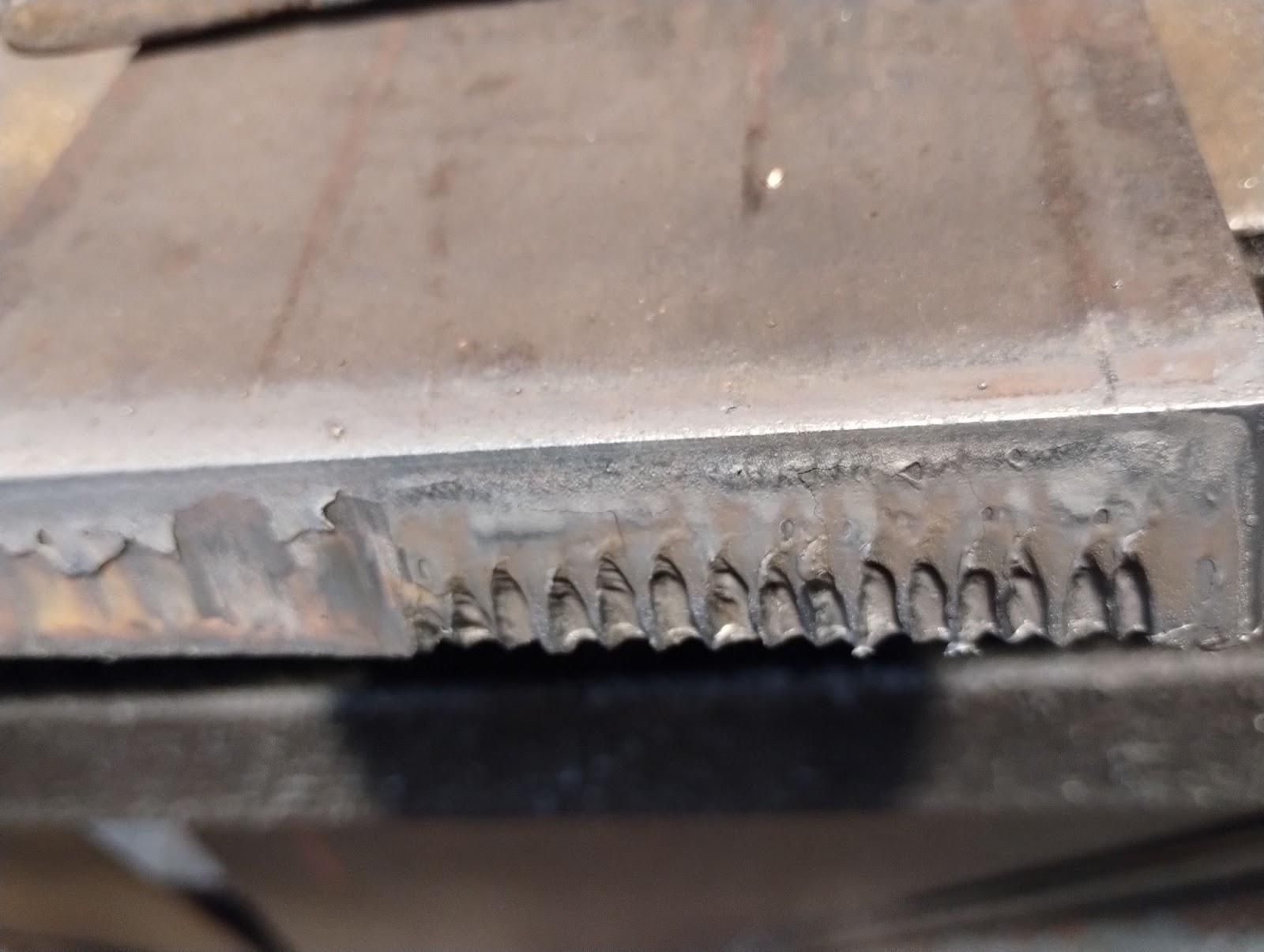 A sample of a cut that was made too slowly and too closely showing a rough edge with jagged metal drips where the cut was made.