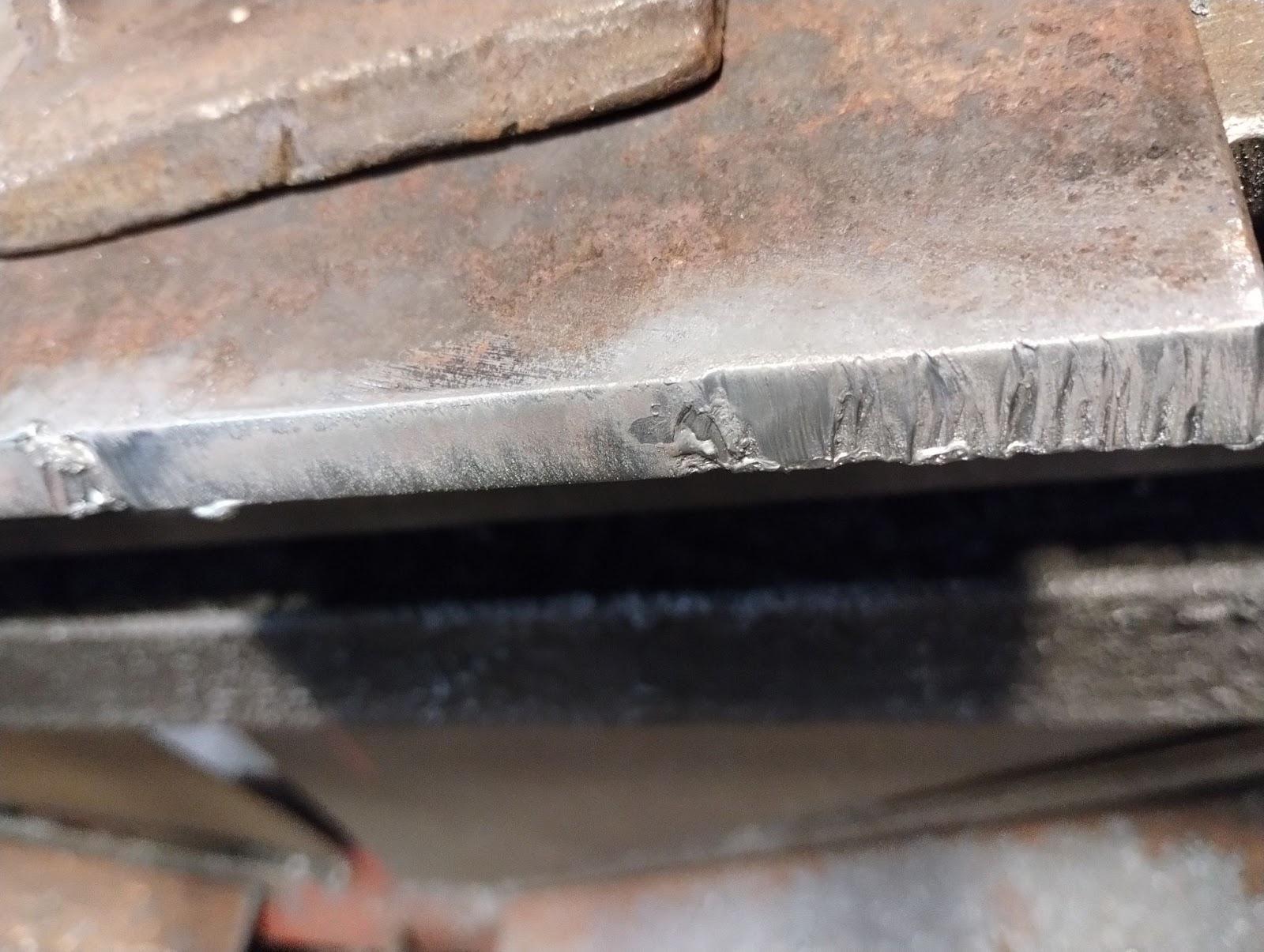 A sample of a cut made too fast with multiple restarts showing that the metal is silvery and jagged in places where the cut was made.