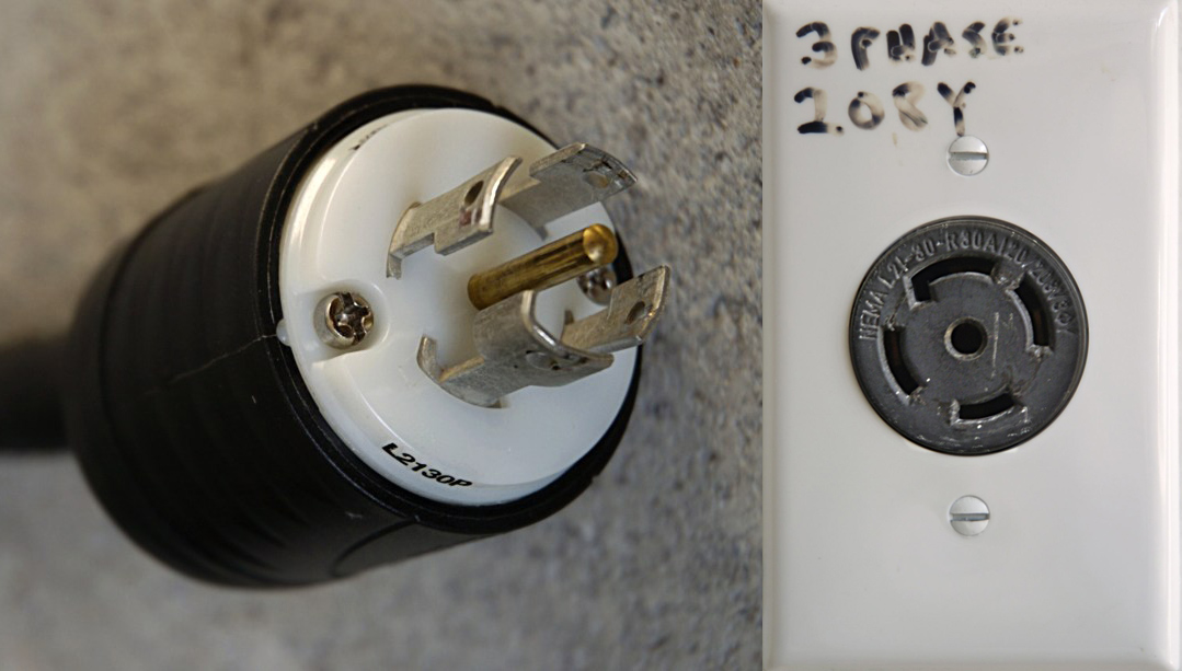 An example of a twist lock plug and receptacle. The plug, which is on the left, has one center prong with a straight pin and four prongs with specific shapes that will only fit the receptacle in a specific way. On the right is the receptacle (outlet) that is made specifically to fit the prongs on the plug. The twist lock plug would fit in the receptacle but would have to be turned so that the plug is secure before the machine can be powered on.