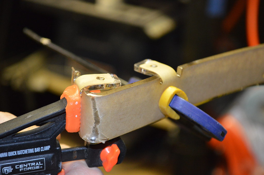 Two clamps are being used to hold metal into shape