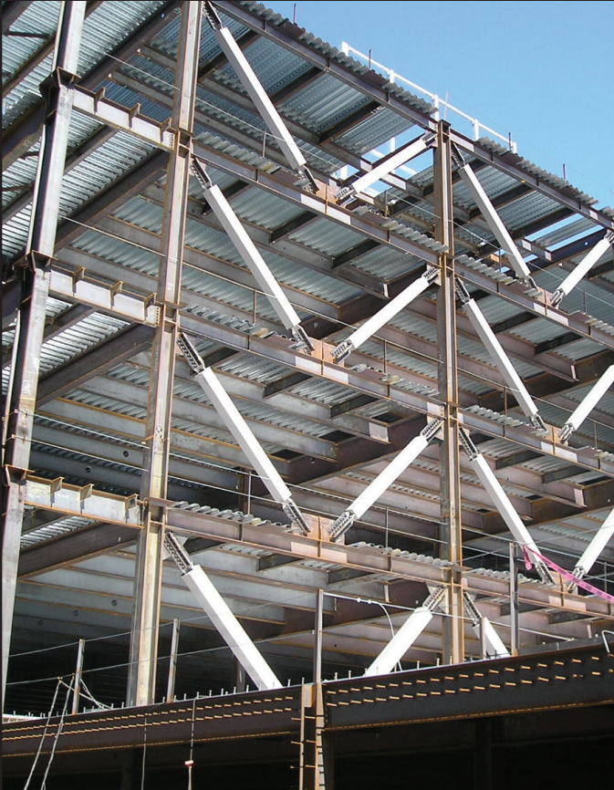 A photograph of a steel structure with white diagonal lines at even intervals between the upright steel beams that form the frame of the building. These diagonal lines are for bracing.