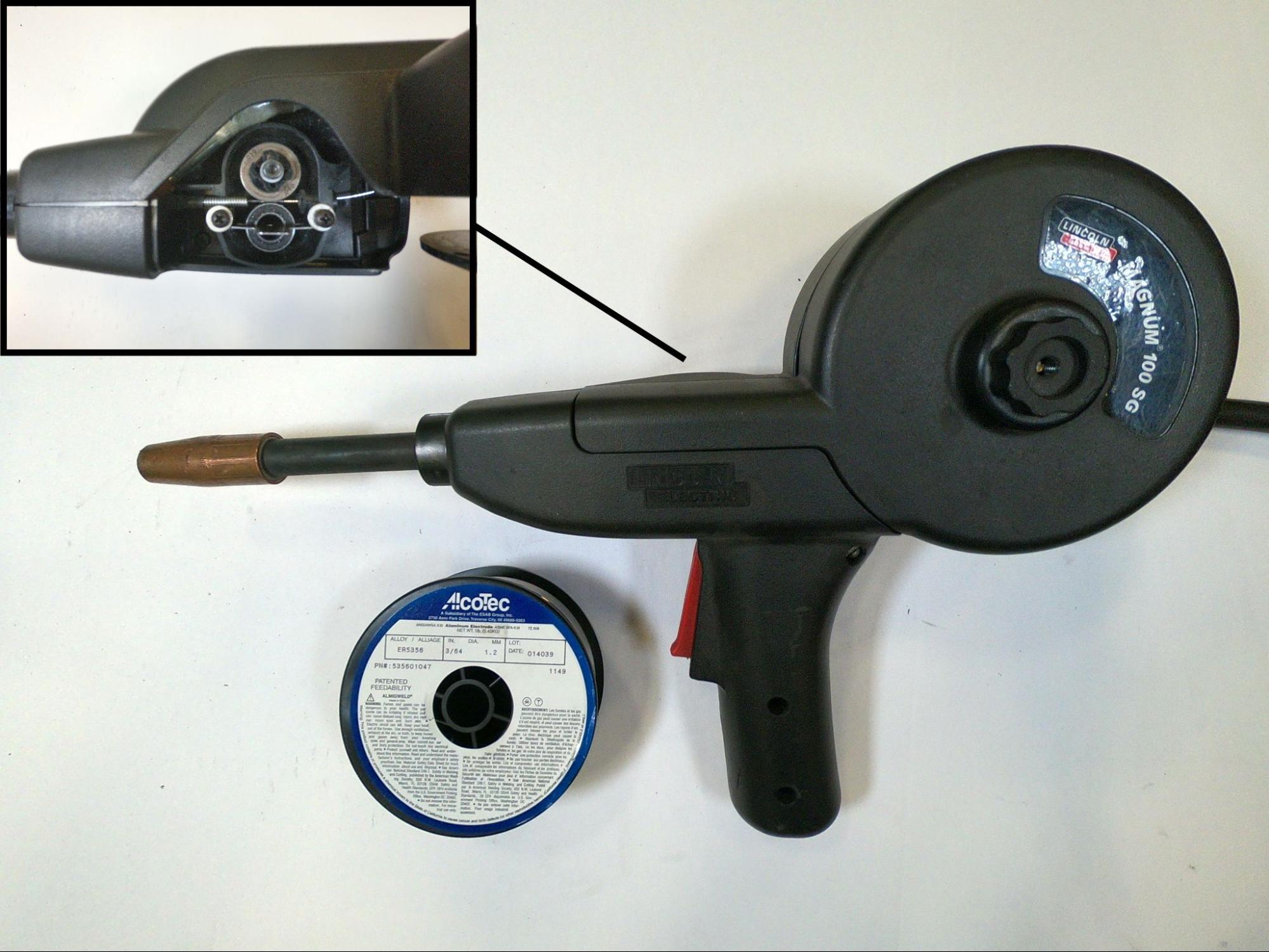 A spool-style welding gun pictured with a typical spool and a close-up of the drive rolls inside the gun.