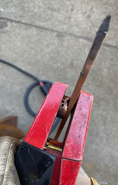 A display showing the carbon electrode, which looks like a long, thin, pointed stick, extending from the holder within 6” of the air holes which are placed below the electrode.