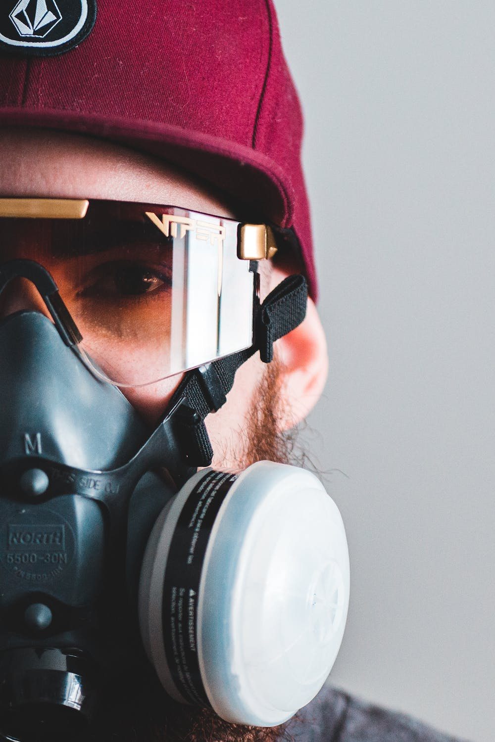 A close-up of a person wearing safety glasses and a respirator