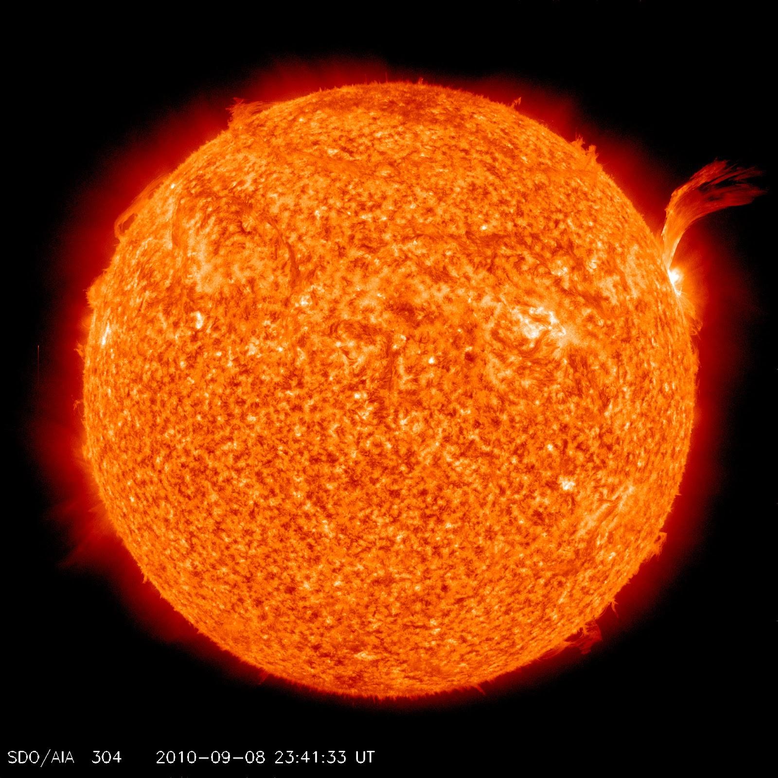 A telescope picture of the Sun, which is a star. The image depicts a glowing orange ball of plasma held together by gravity.