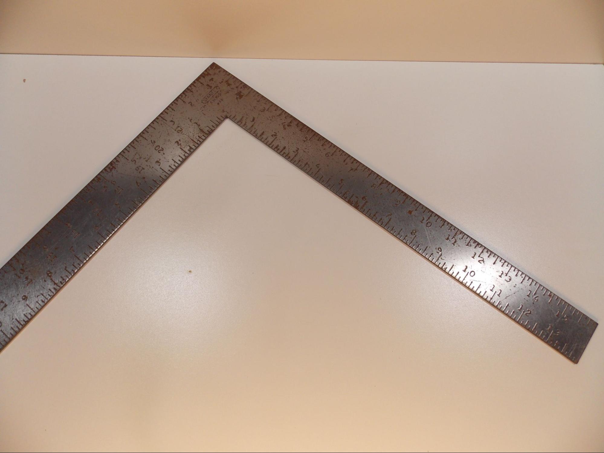 A picture of a framing square which looks like two flat metal rulers connected at a right angle.