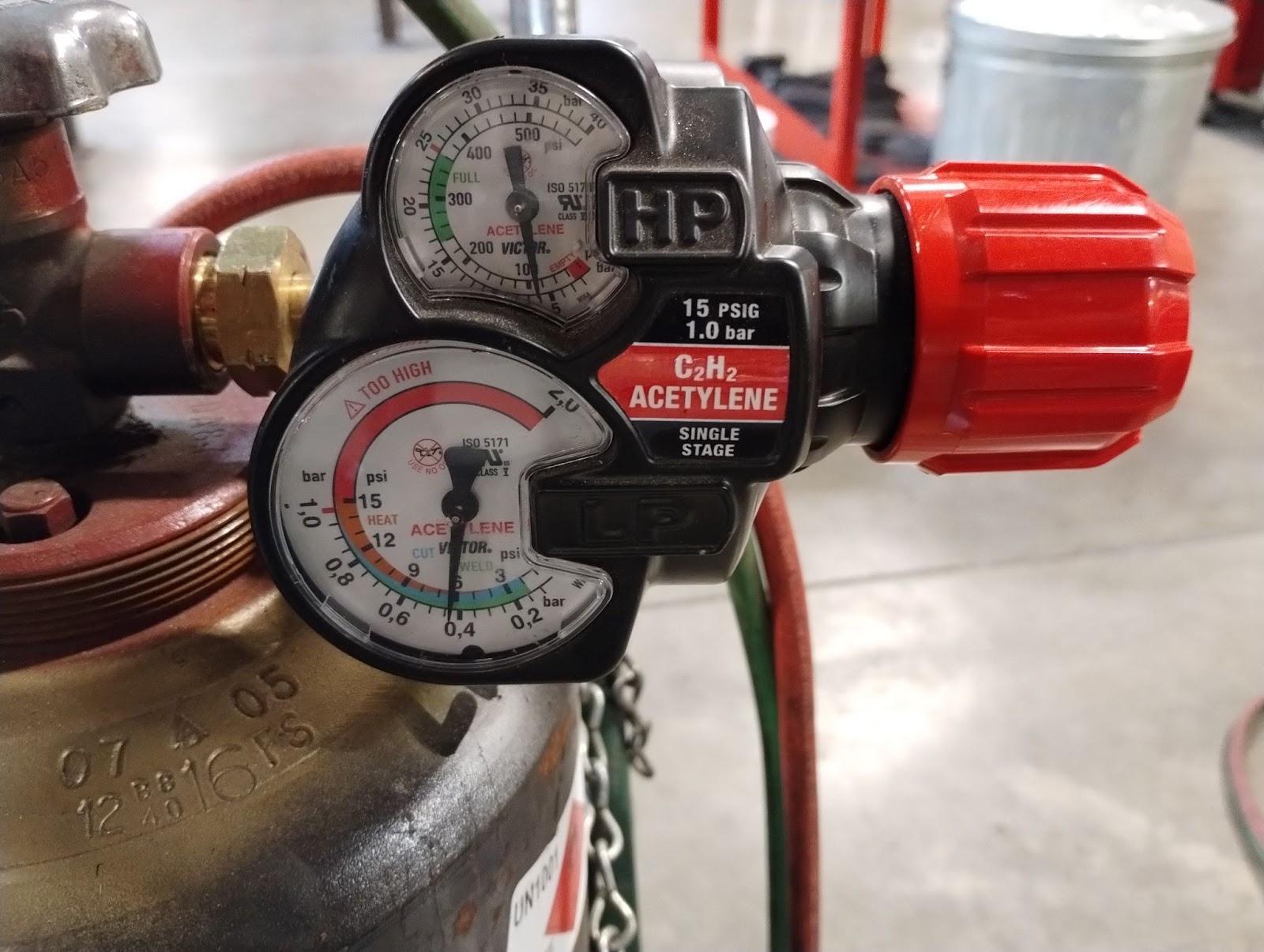 Acetylene regulator with two pressure gauges. The first and smallest regulates the pressure of the gas in the tank. The second, slightly larger gauge measures the pressure of the gas flowing to the flame used in OFC. The larger gauge has a red line showing that above 15 psi, the working pressure is too high.