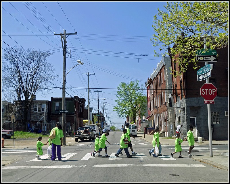 Children crossing the road in bright yellow tshirts with 2 adults