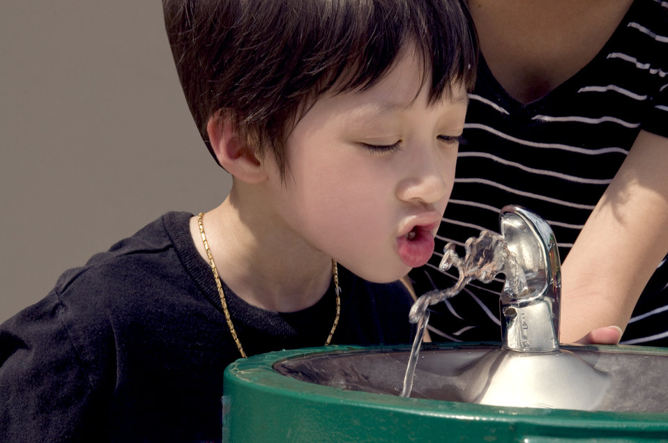 Child drinking from drinking fountain