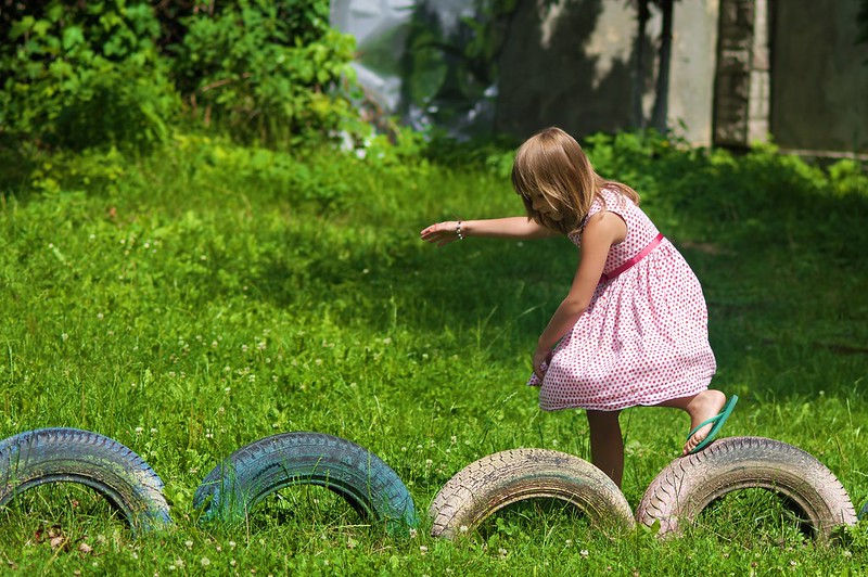 Girl playing on submerged tires