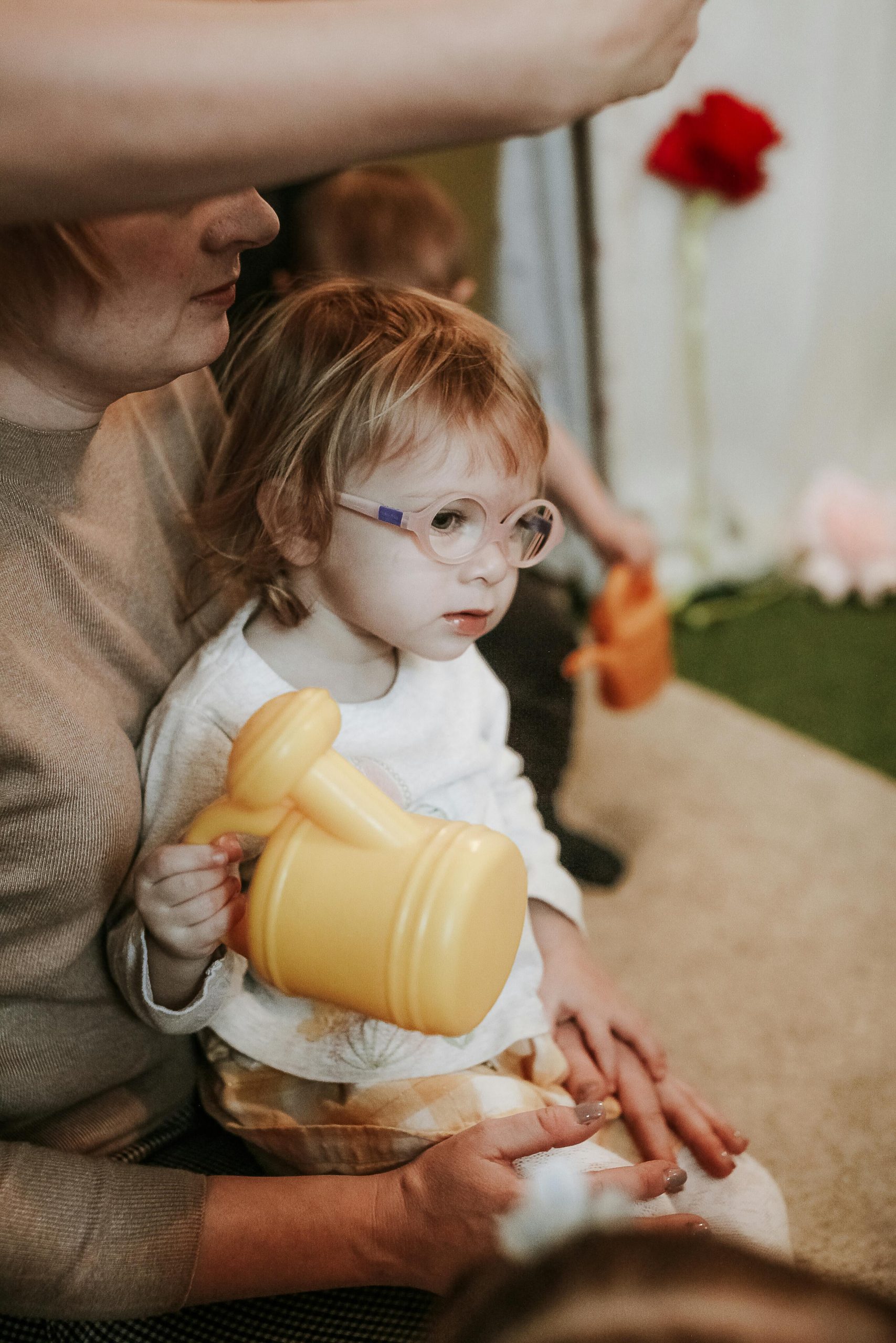 Girl wearing glasses holding plastic watering can