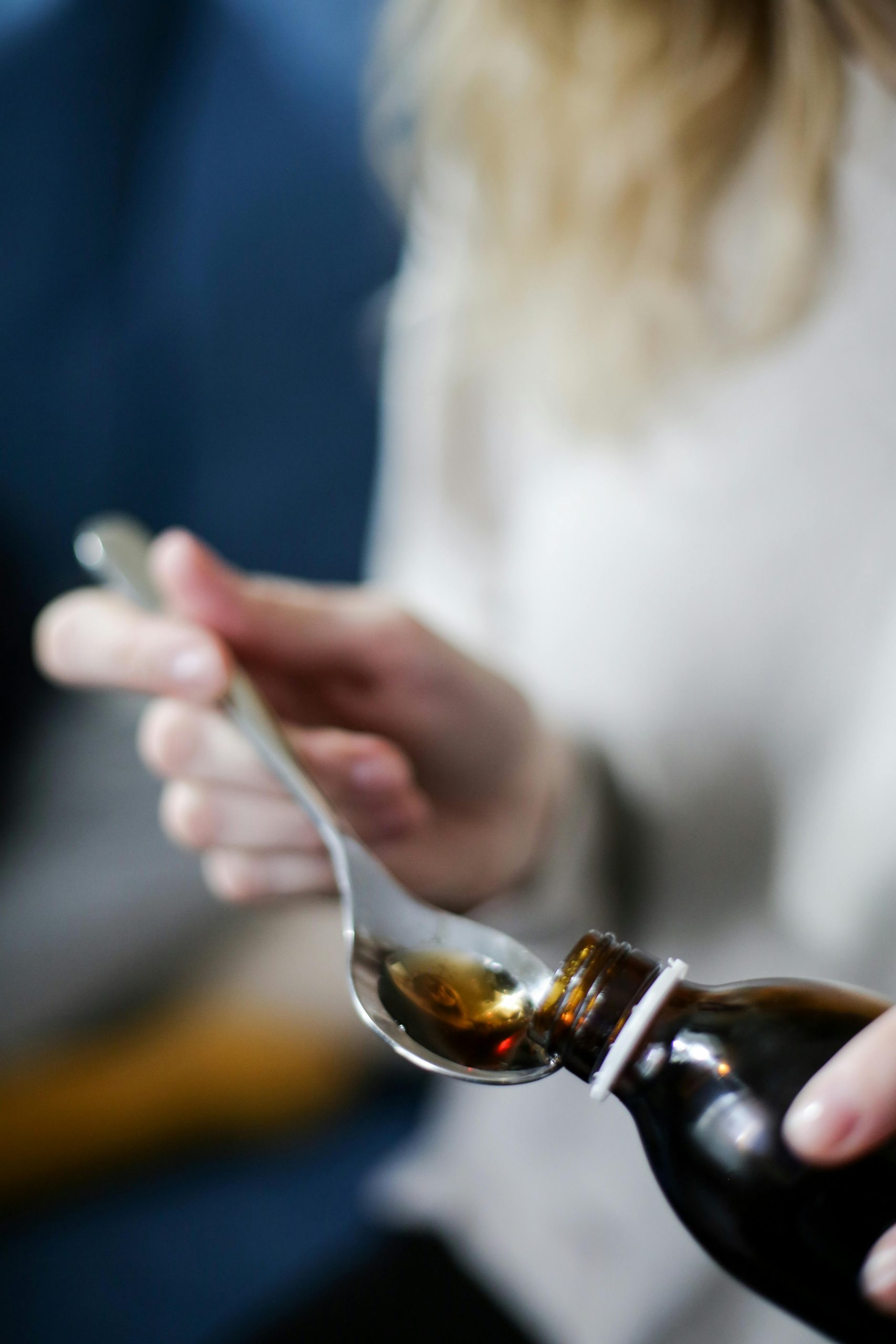 Medicine being poured into a spoon