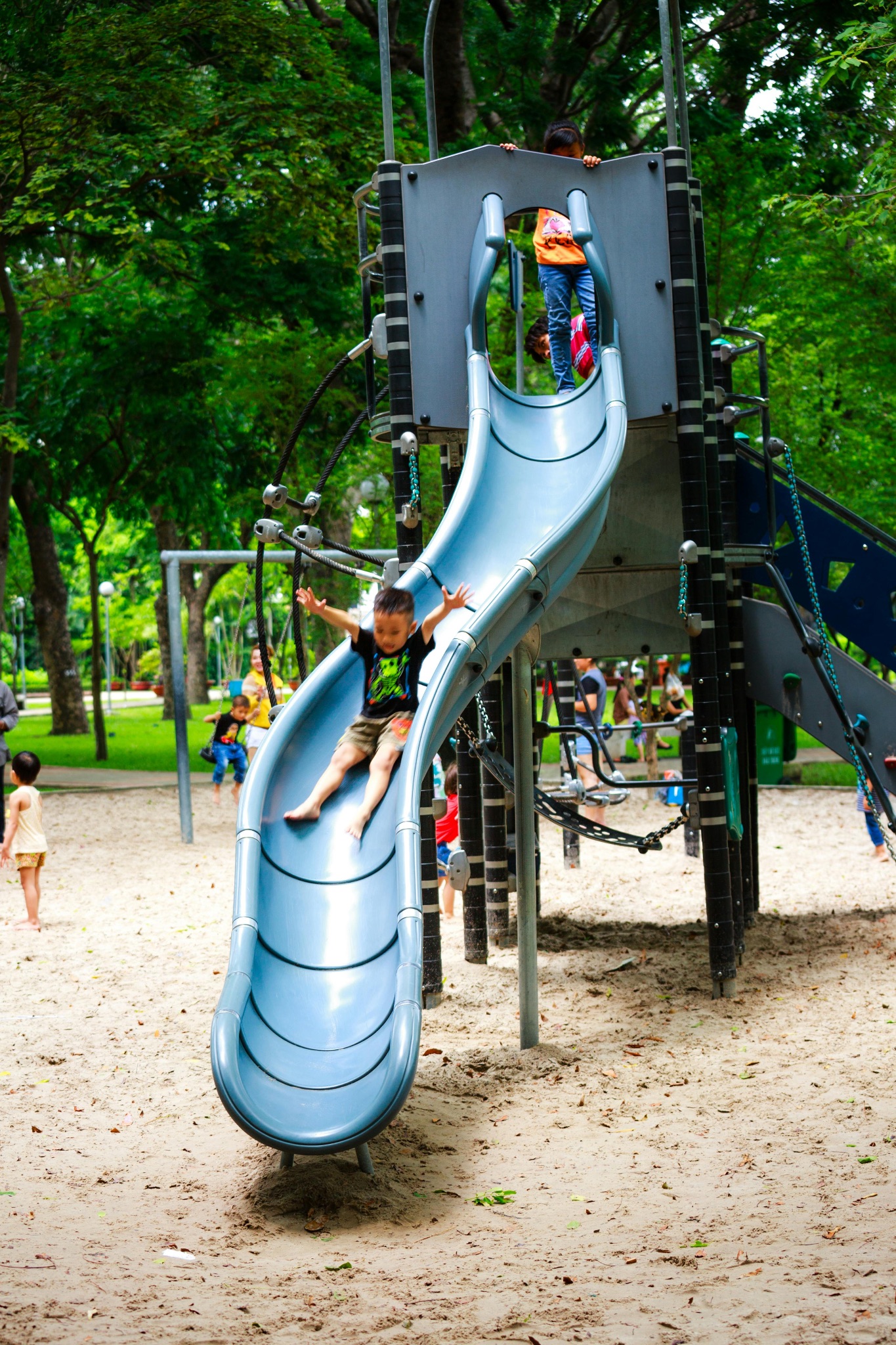 Toddler slides down a playground slide.