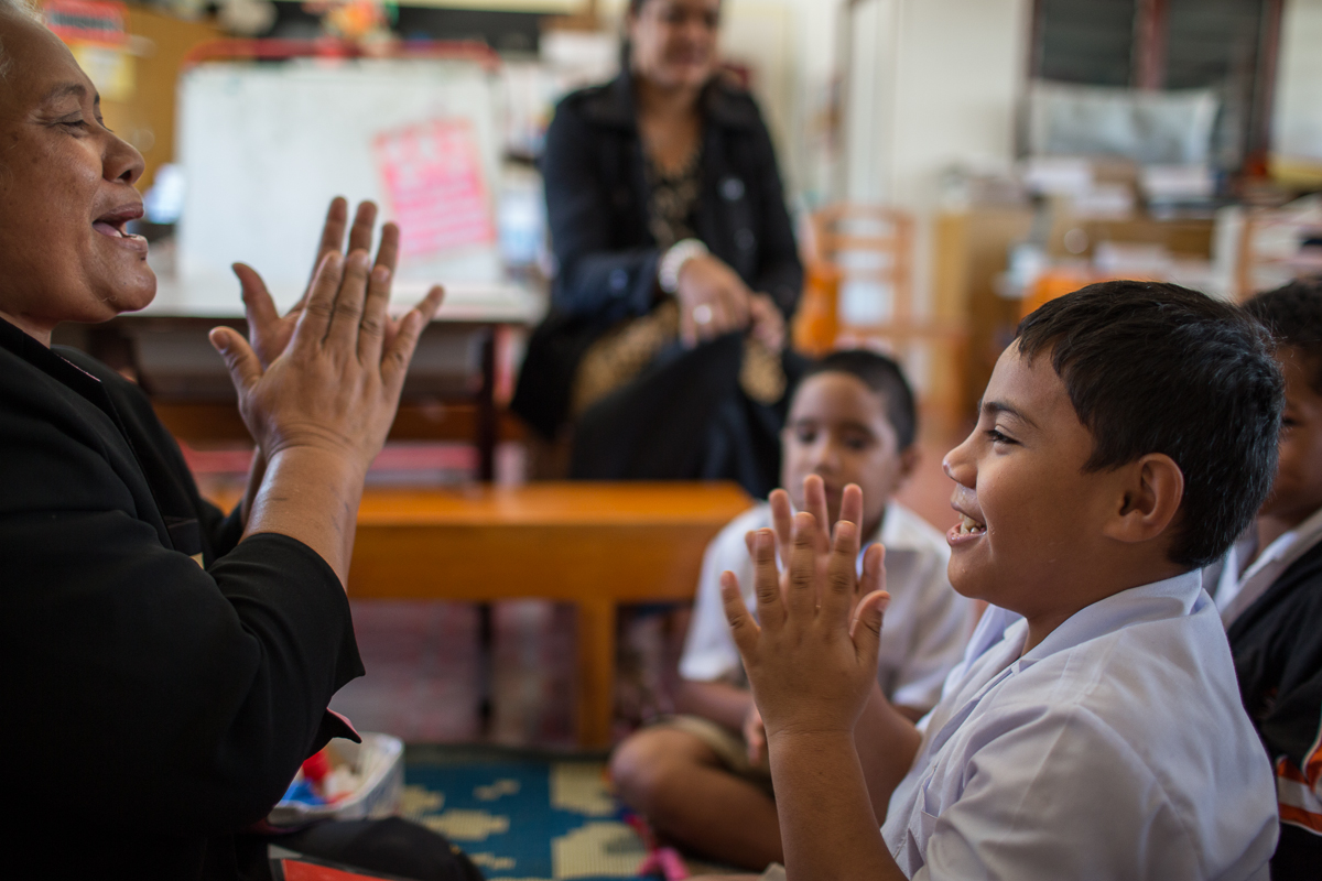 Child playing a hand clap game with an adult.