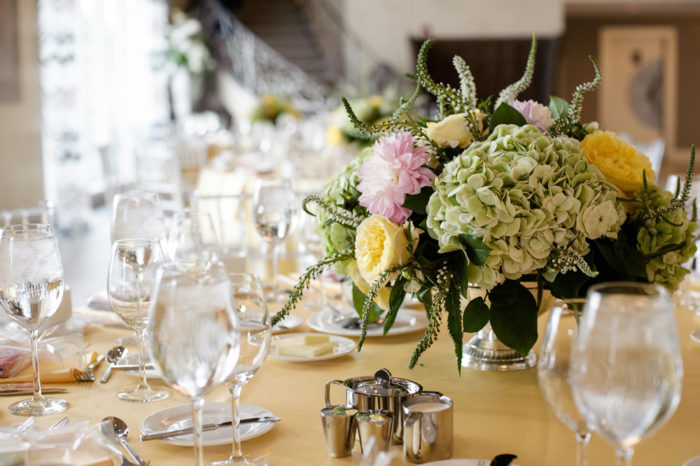 A formal dining table with a bouquet of flowers.