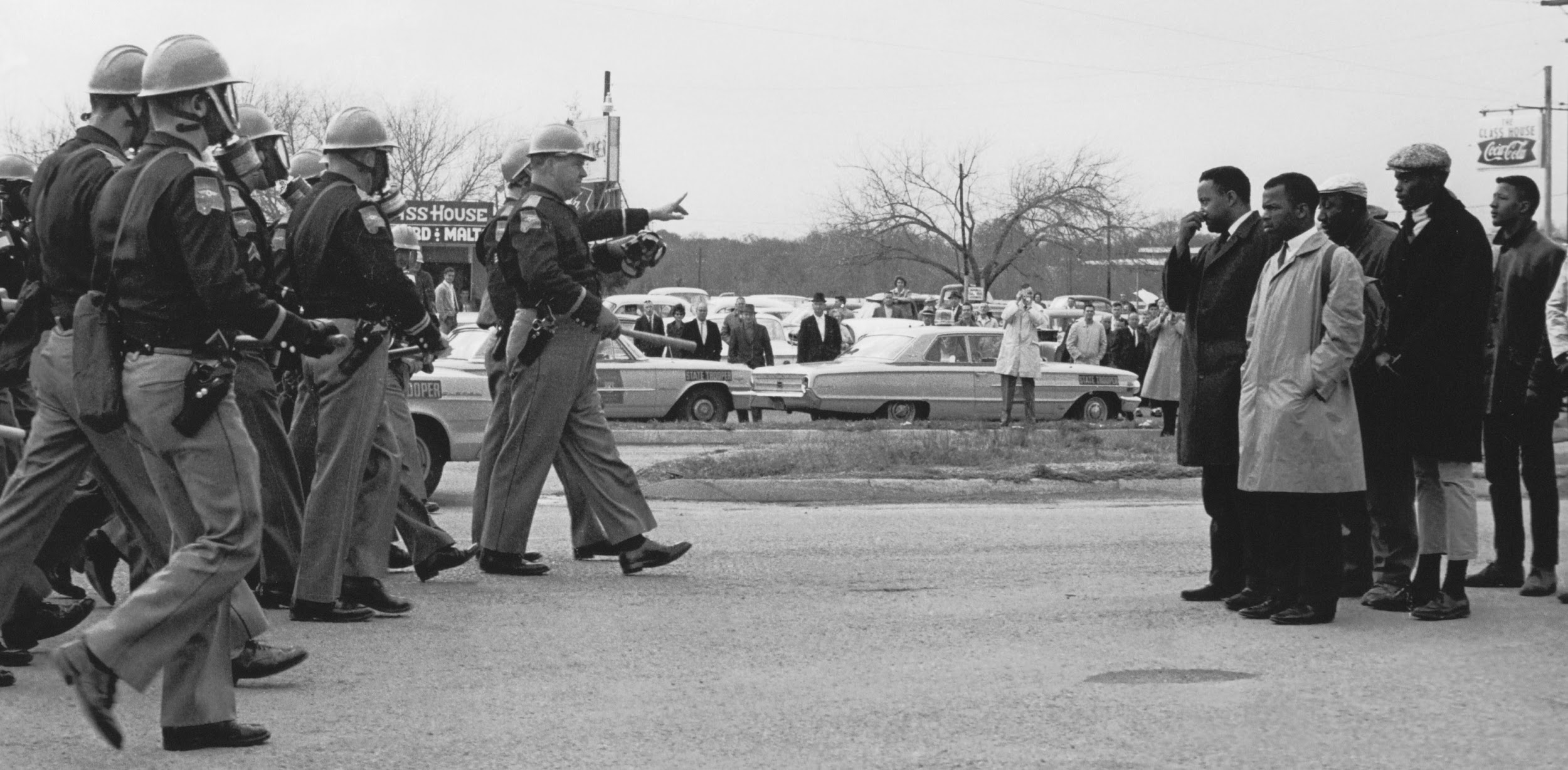 Photograph capturing the brief moment when the swarm of law enforcement approached a stationary assembly of non-violent, Black American protesters.