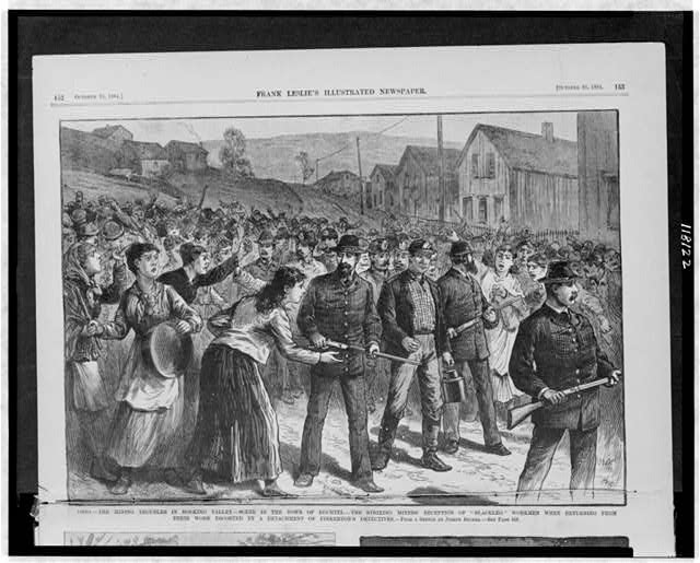 Illustration of working miners returning home from work, accompanied by gun-toting Pinterton Detective Agents, passing by enraged striking miners.