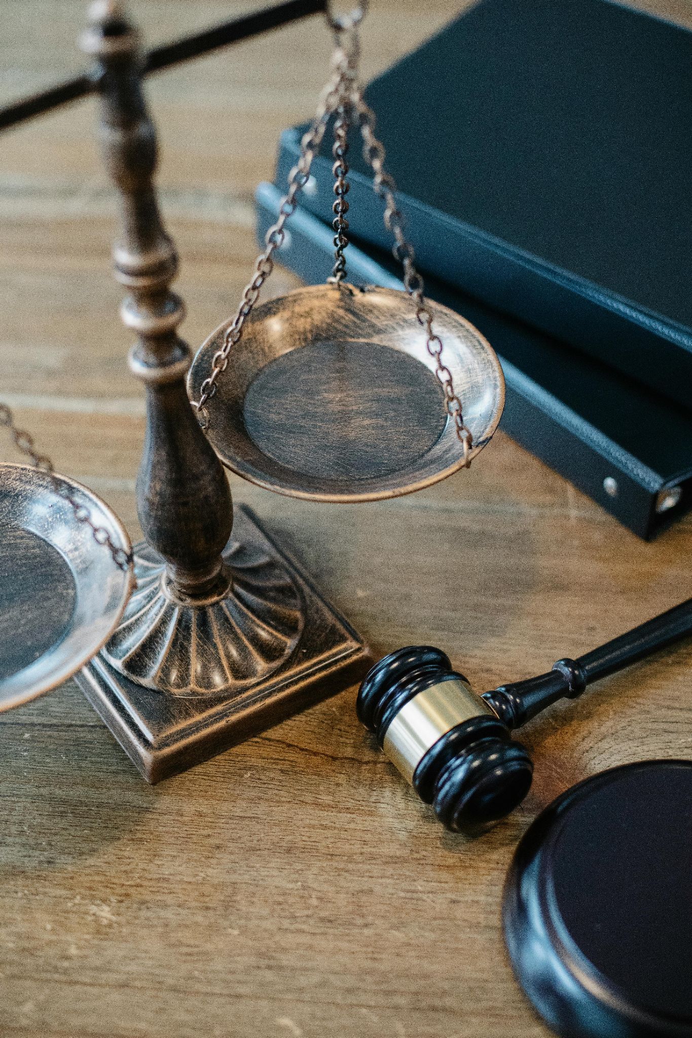 A gavel, bronze scales of justice, and leather bound law books.