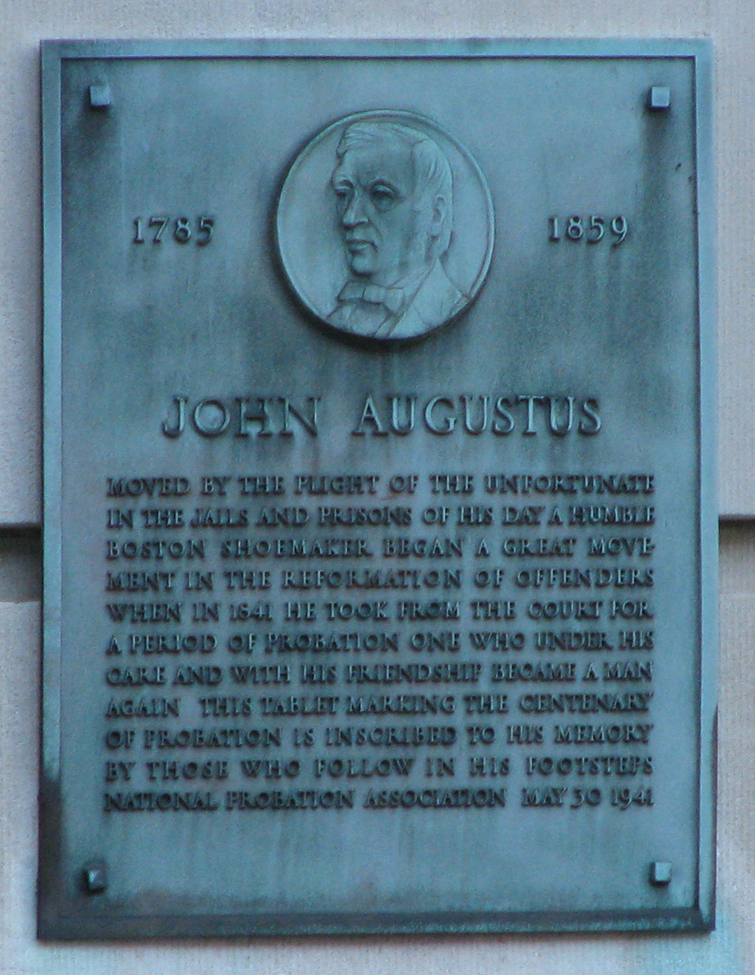 Photograph of a plaque commemorating John Augustus, featuring an engraved likeness of him.