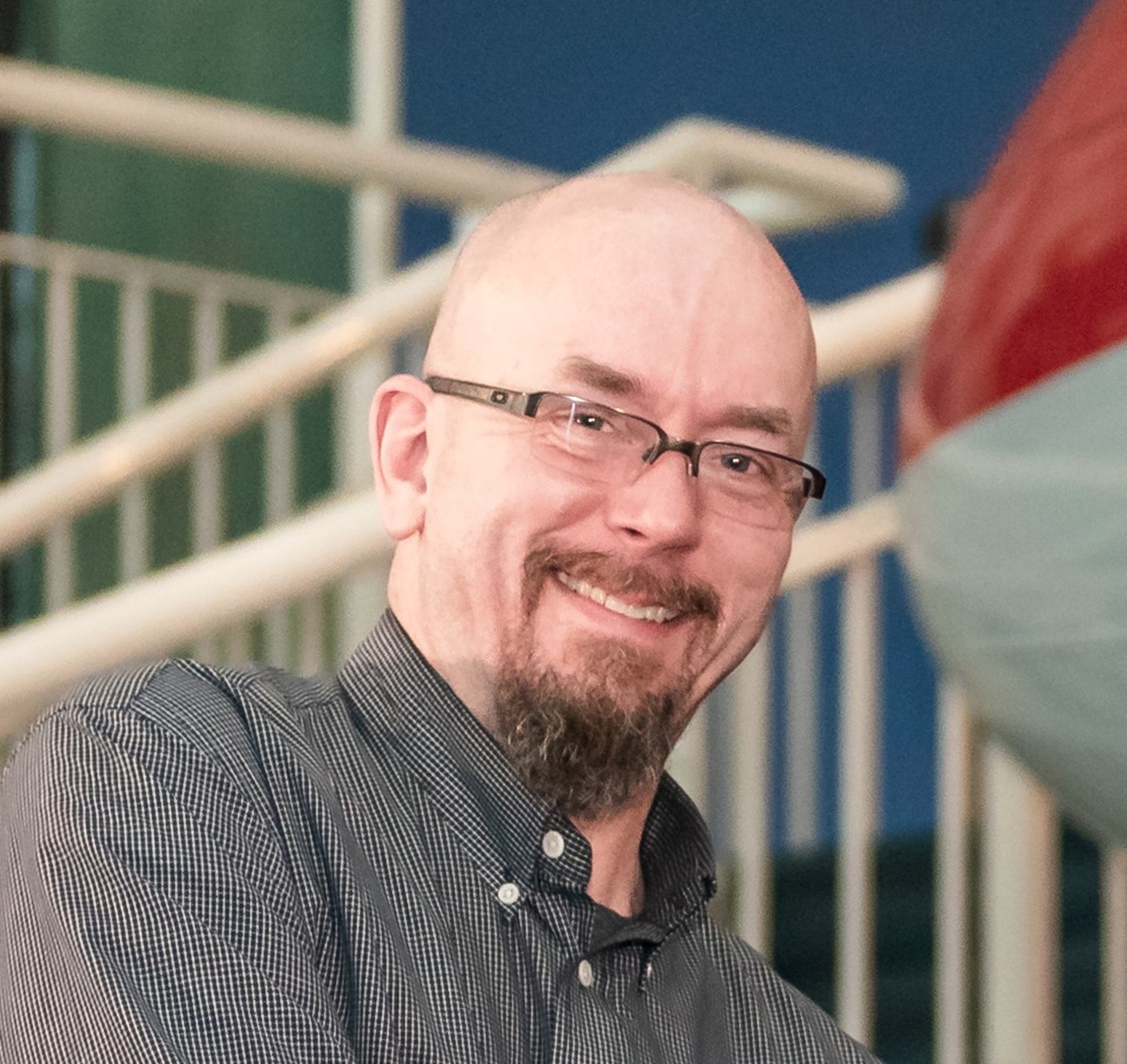 Photo of a man with glasses smiling