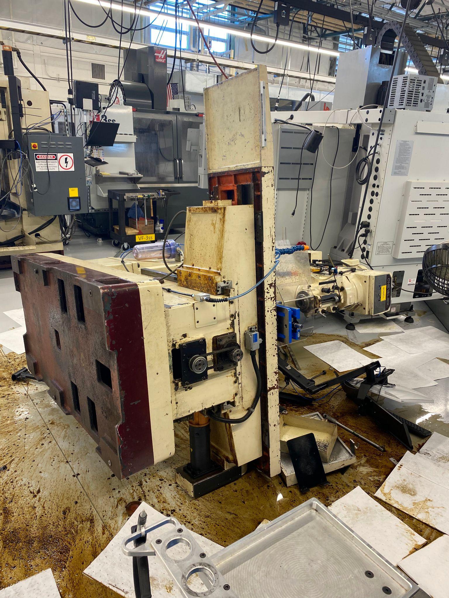 A Chevalier bed mill is laying on its side due to an incident while moving the machine.