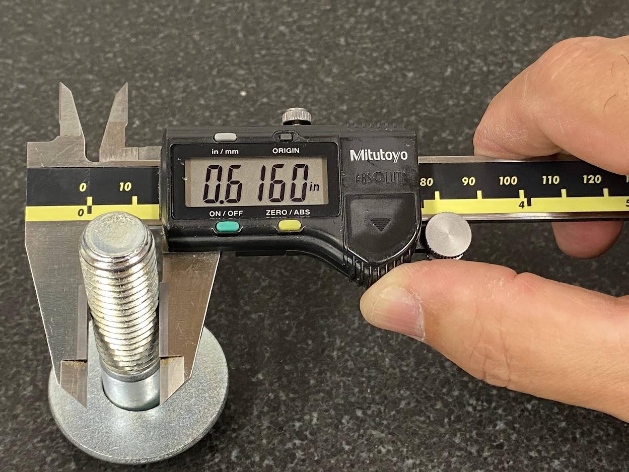 A slide caliper measuring a bolt diameter.