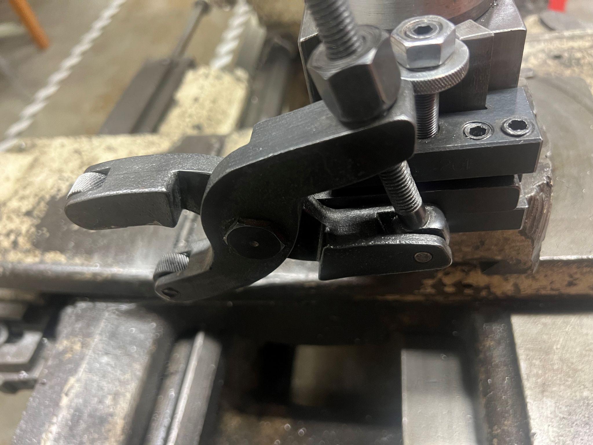 A pinch knurling tool mounted on a tool post on a manual lathe.