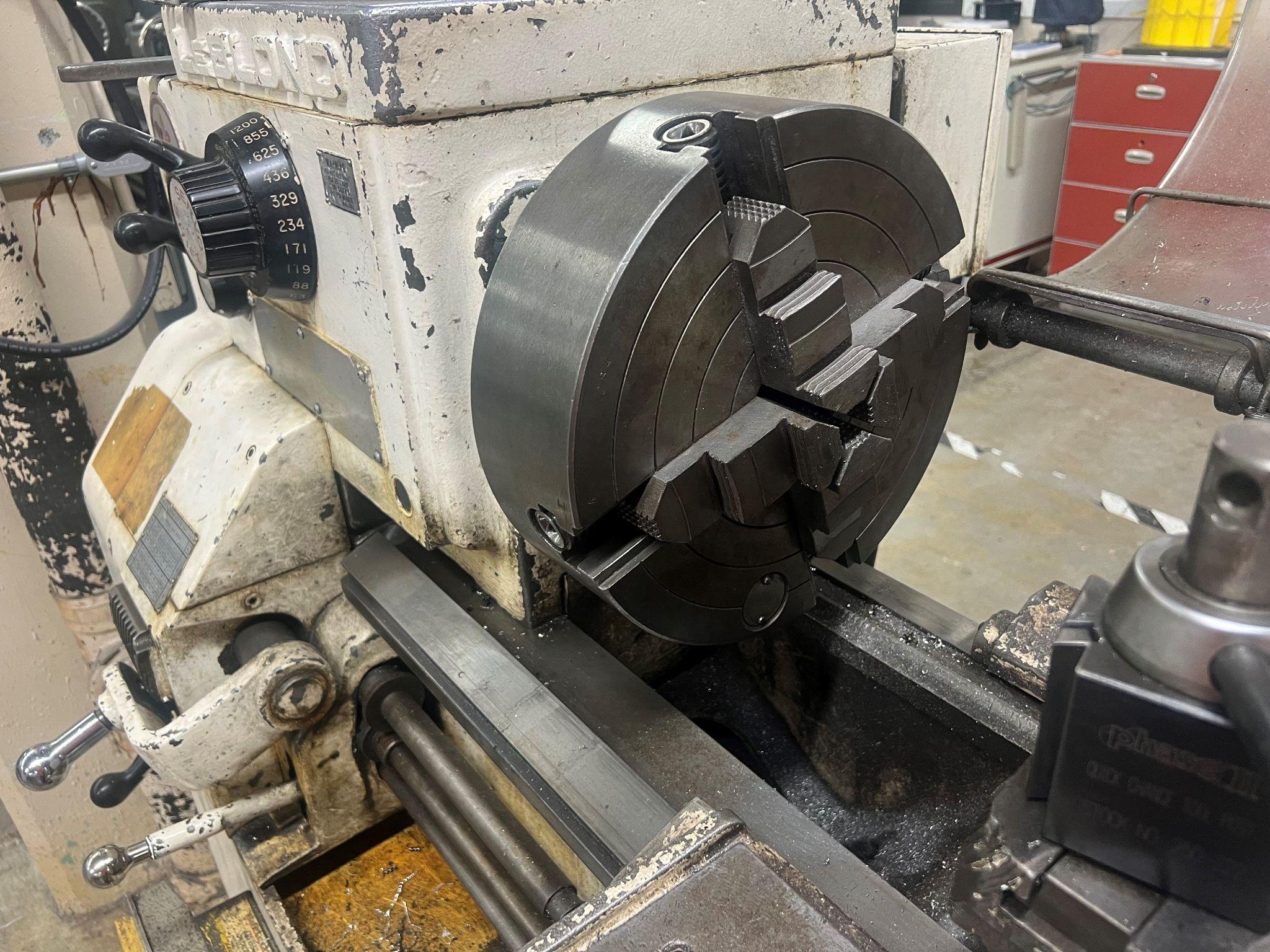 Four jaw chuck on a manual lathe. Tool post in foreground.