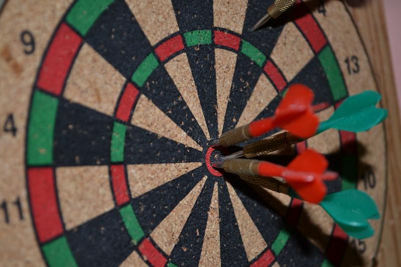 A dart board with several darts stuck into it.