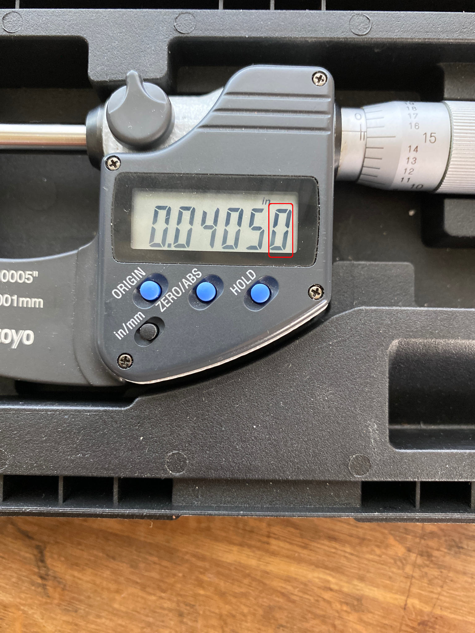 A digital micrometer with a five decimal digit display, showing the number 0.04050.