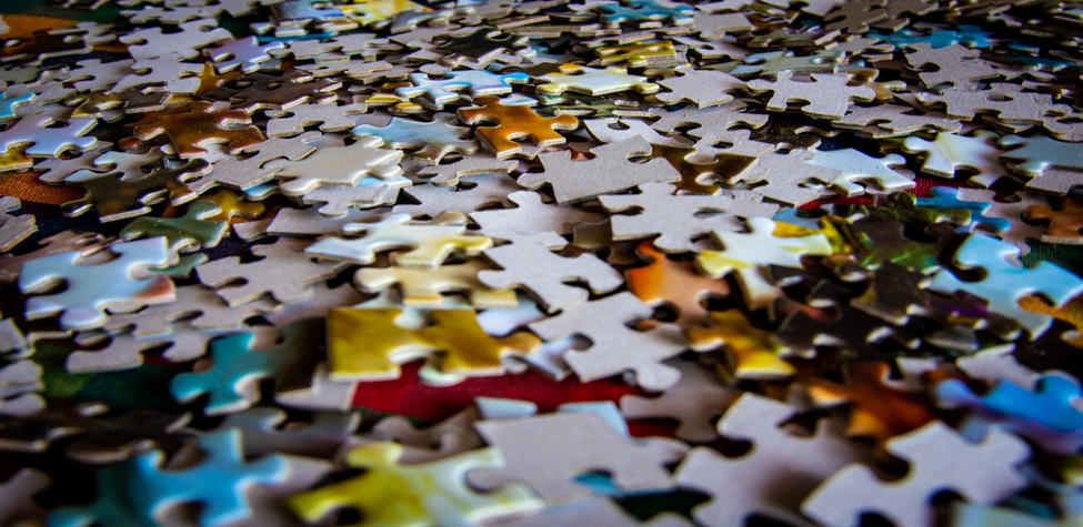 Jigsaw puzzle pieces are scattered about.